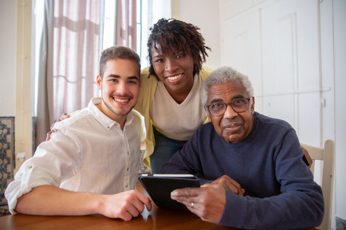 A friendly caregiver helping a smiling senior